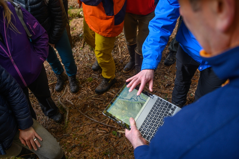 researchers analyze stream samples on a river bank