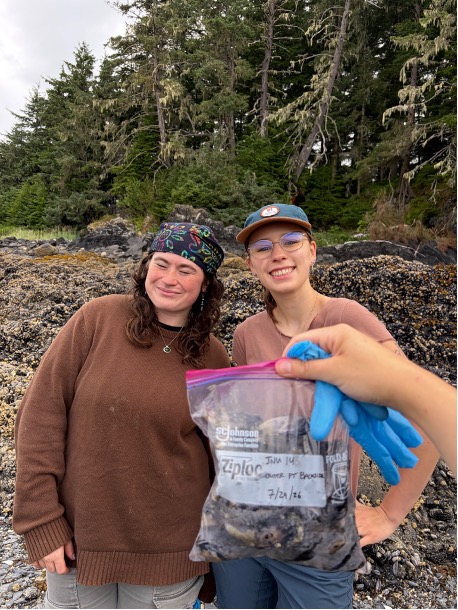 ACRC interns pose on a beach with a bag of collected mussels